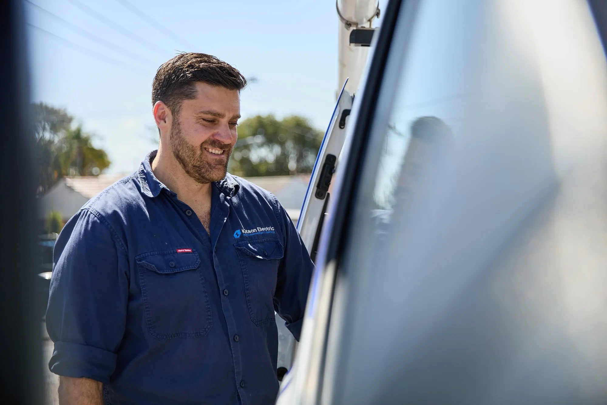 Anthony Kitson smiling beside the Kitson Electric van