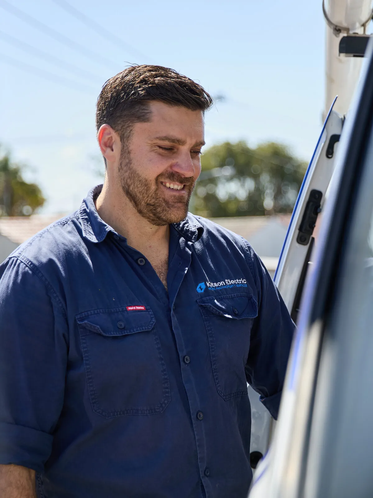 Anthony Kitson smiling beside the Kitson Electric van