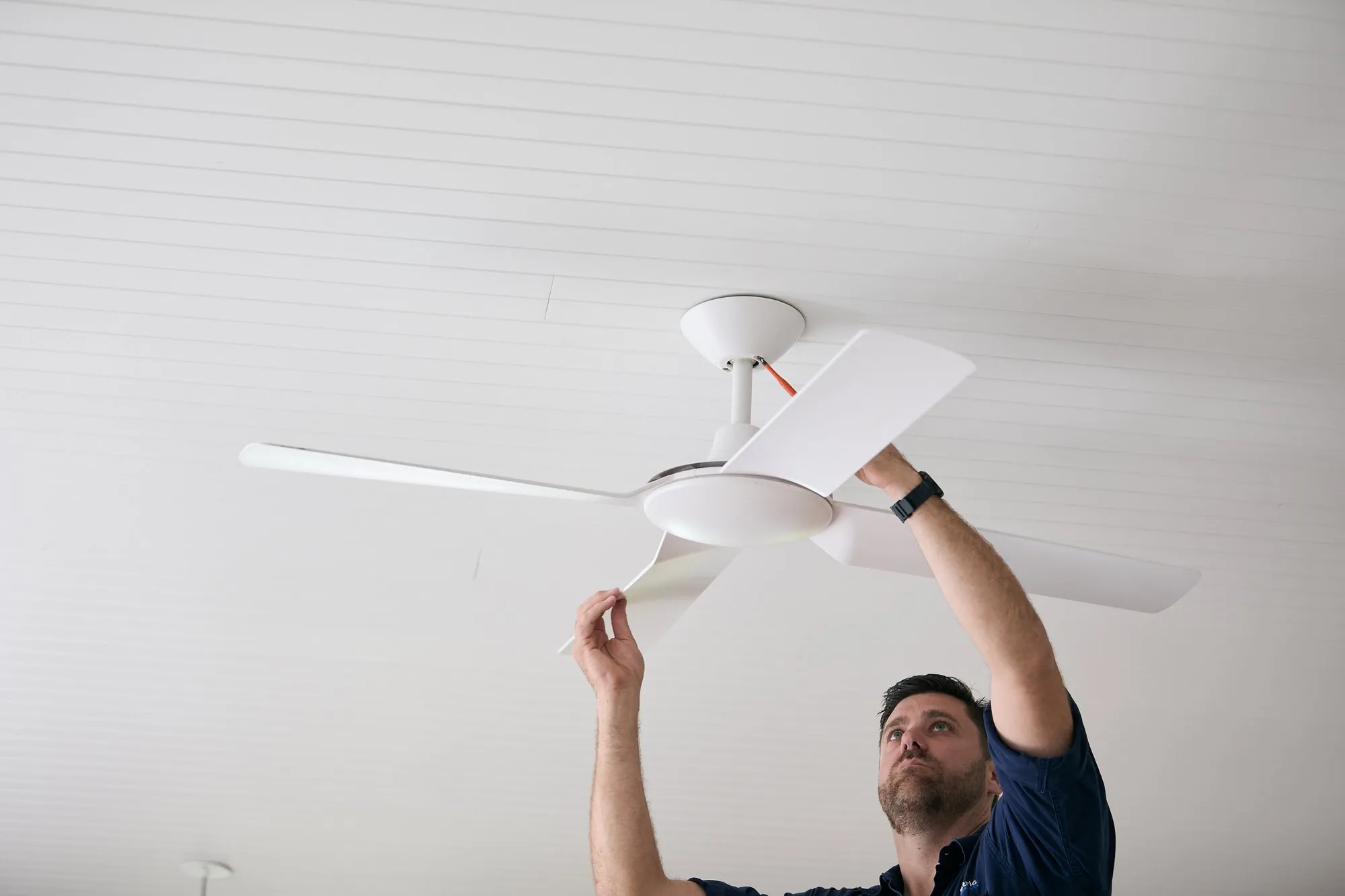 Anthony Kitson fitting a ceiling fan blade