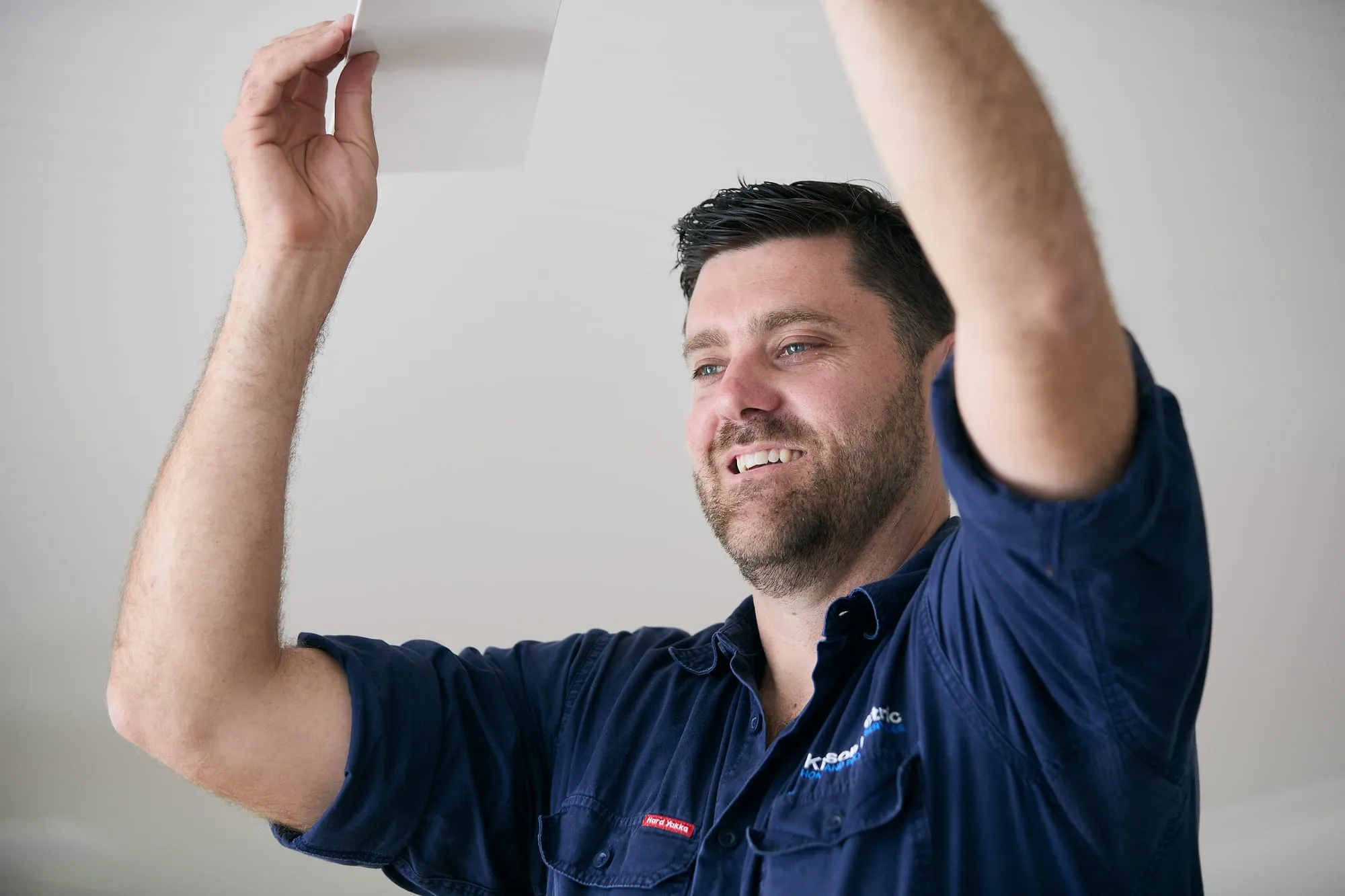 Anthony Kitson fitting a ceiling fan, close up