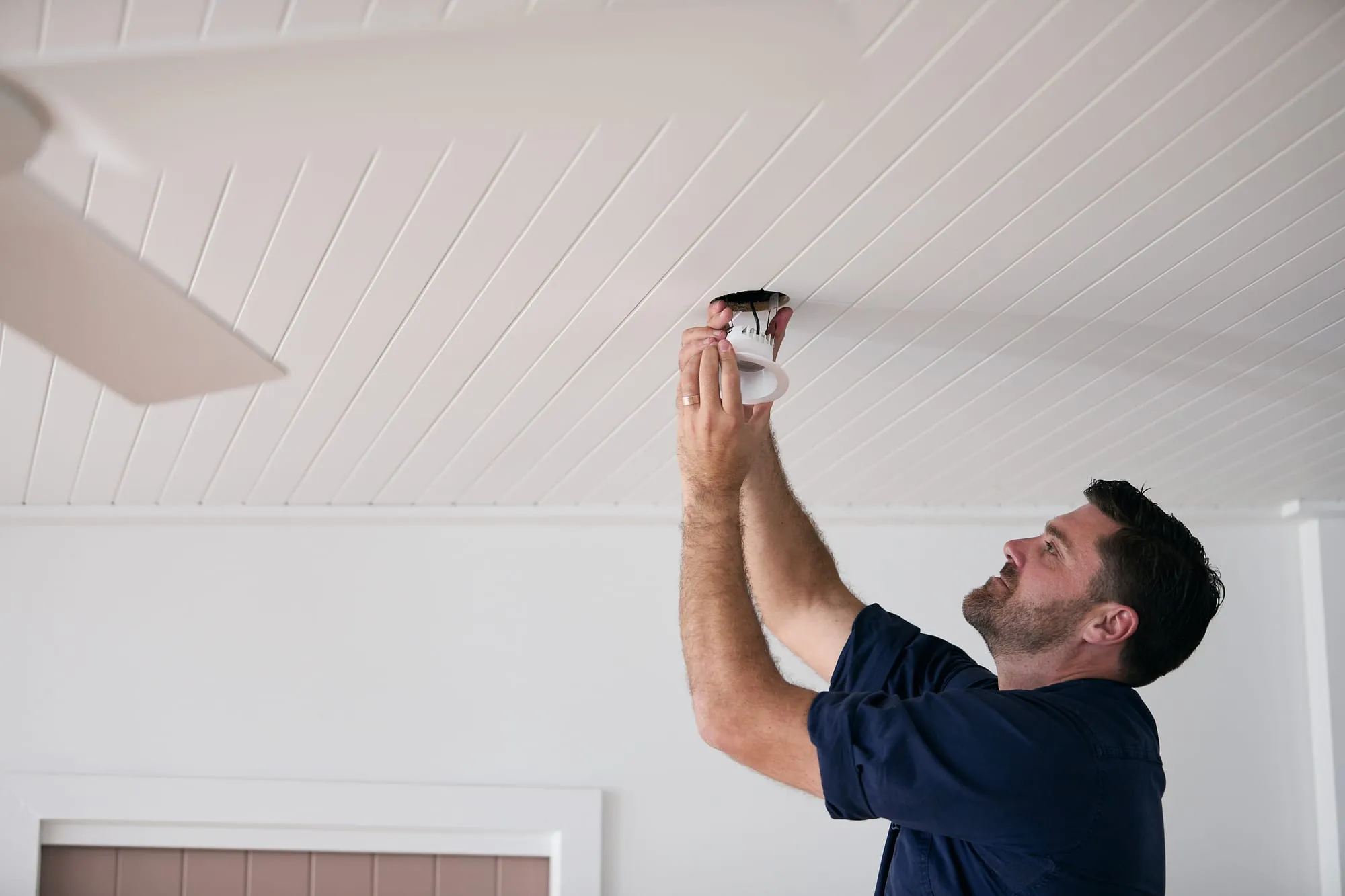Anthony Kitson fitting a downlight in a Newcastle home