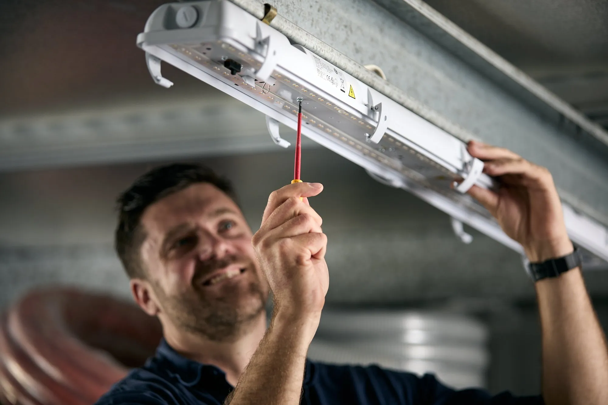 Anthony Kitson installing an LED batten light