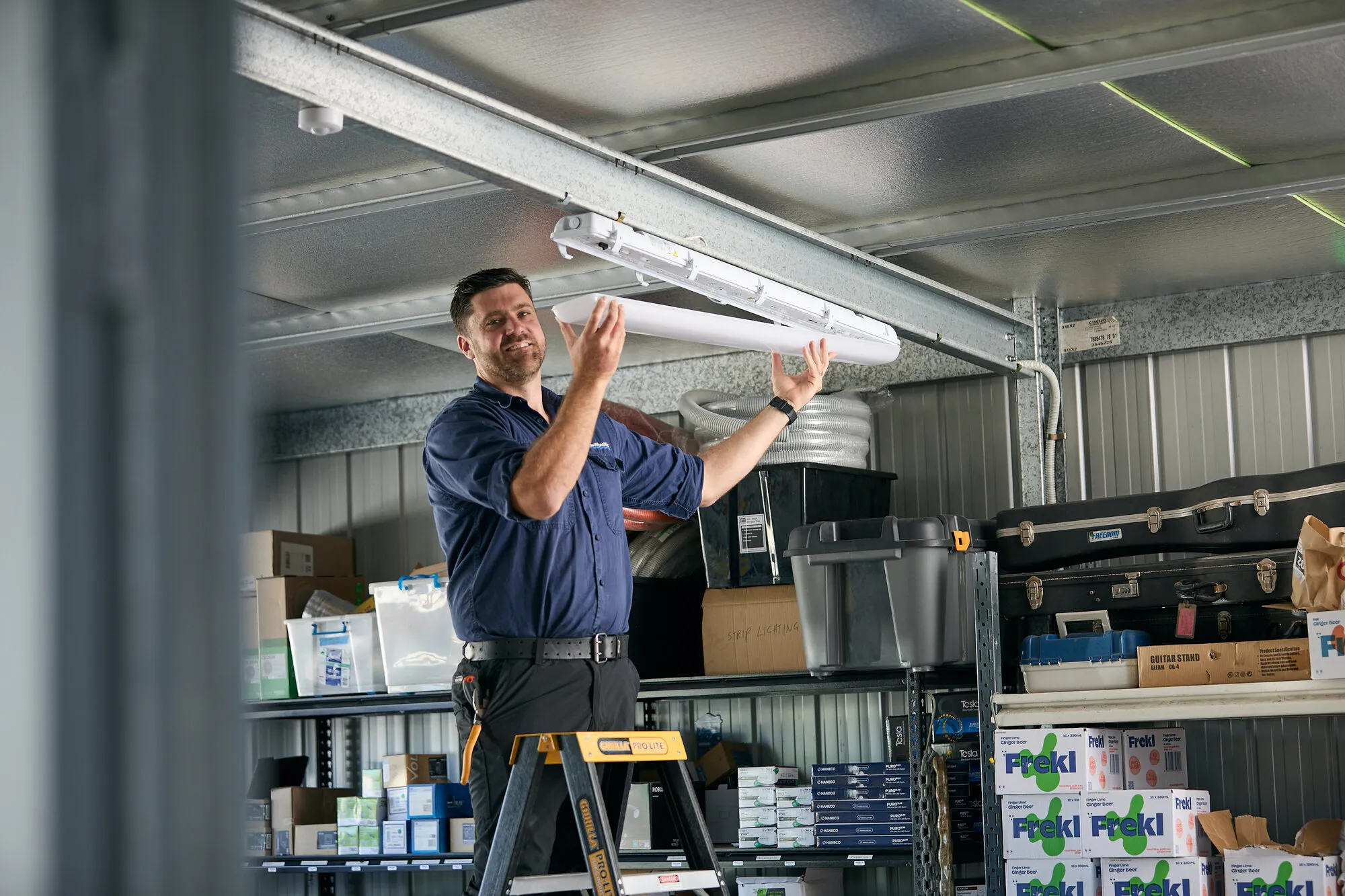 Kitson electrician installing LED batten lighting in a commercial warehouse