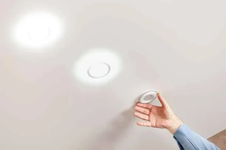A hand fitting a downlight
