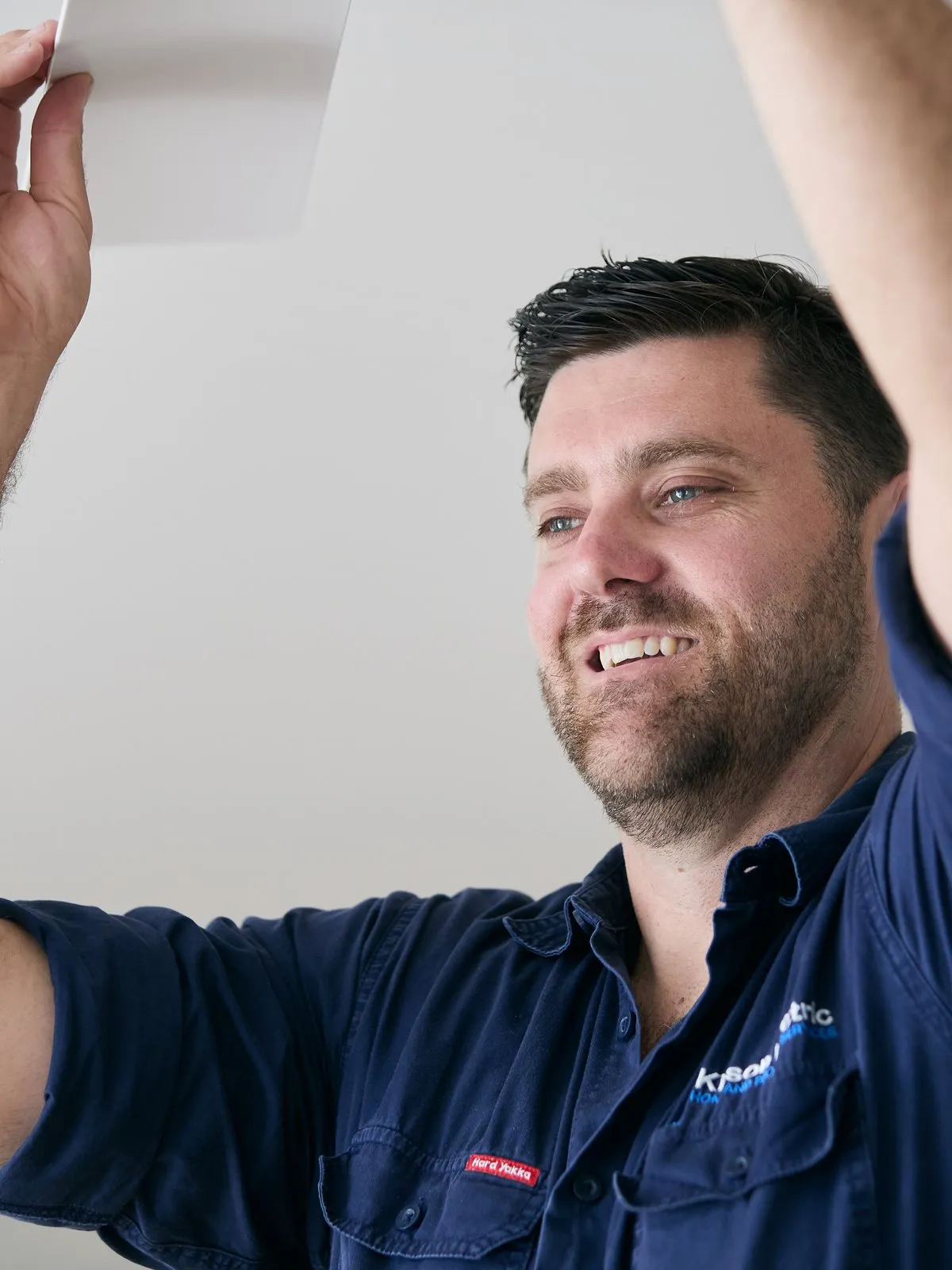 Anthony Kitson fitting a ceiling fan, close up