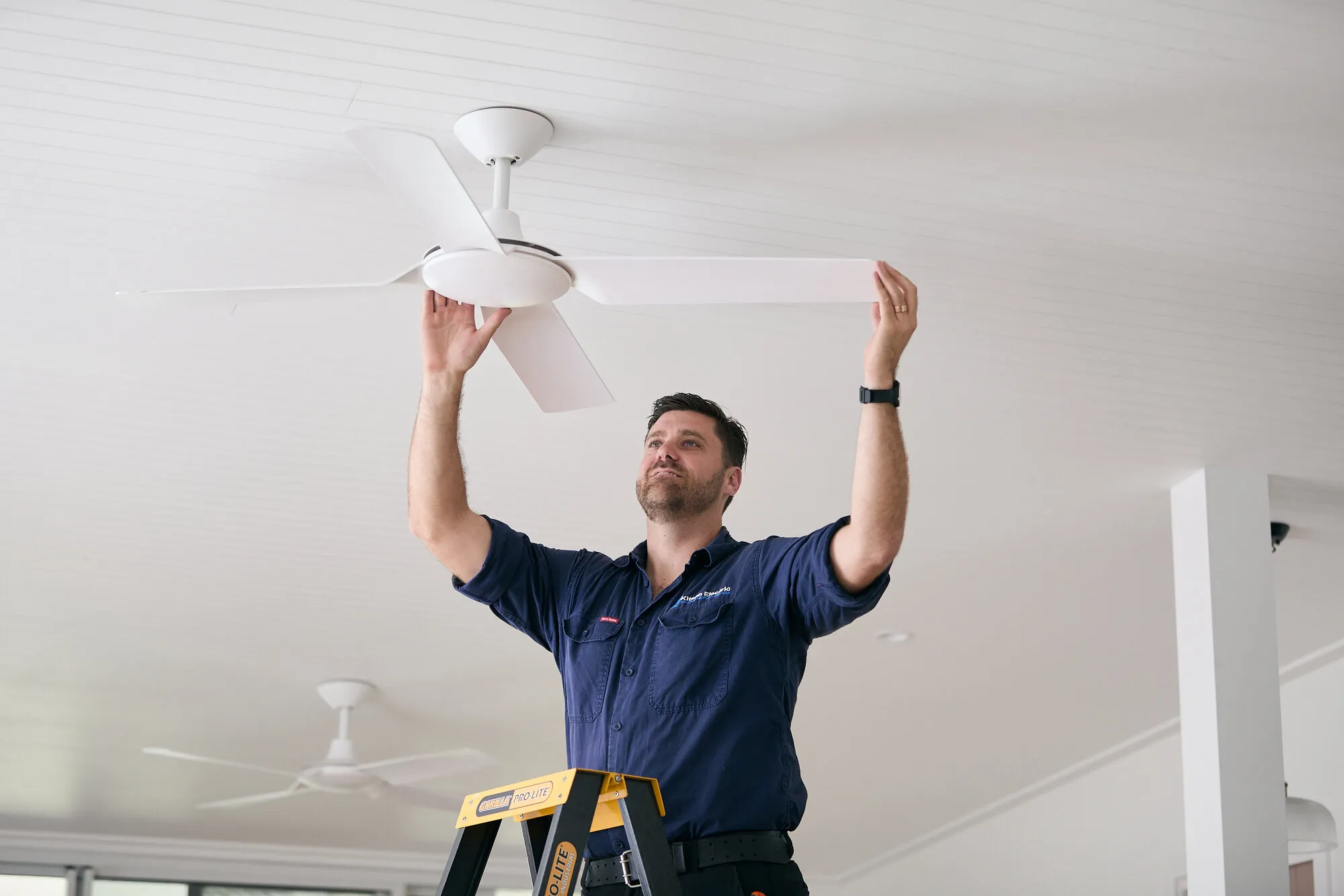 Kitson electrician installing a ceiling fan in a Newcastle home