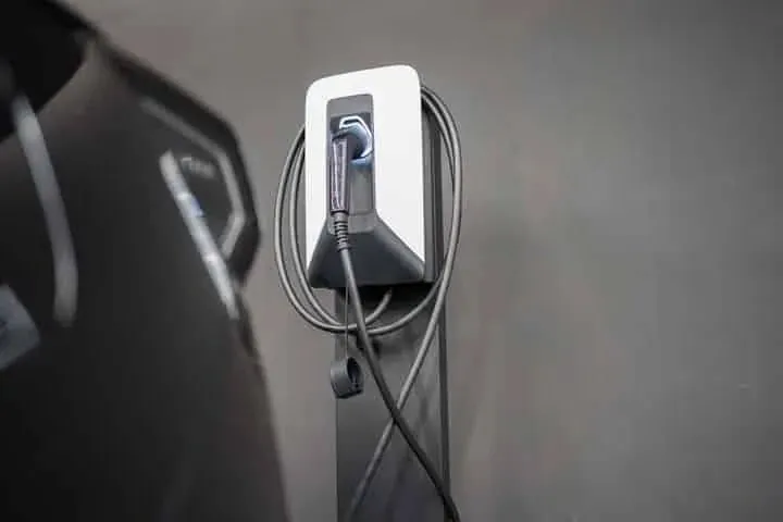 An EV charger beside a parked car
