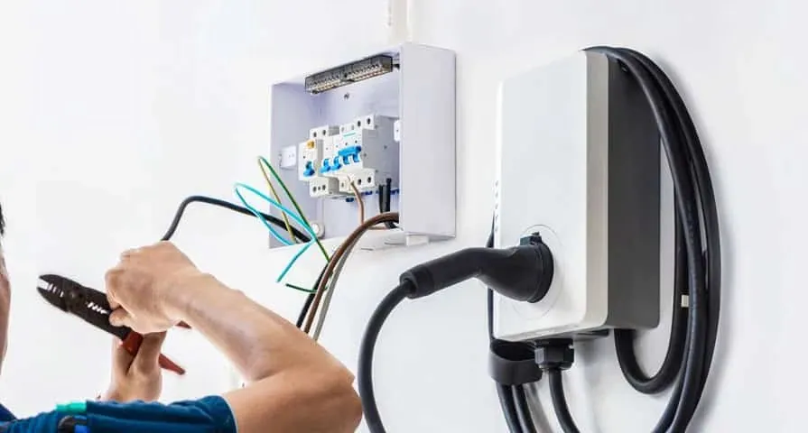 Wall-mounted EV charger being wired to a home switchboard