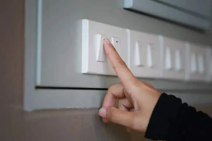 A finger on a light switch