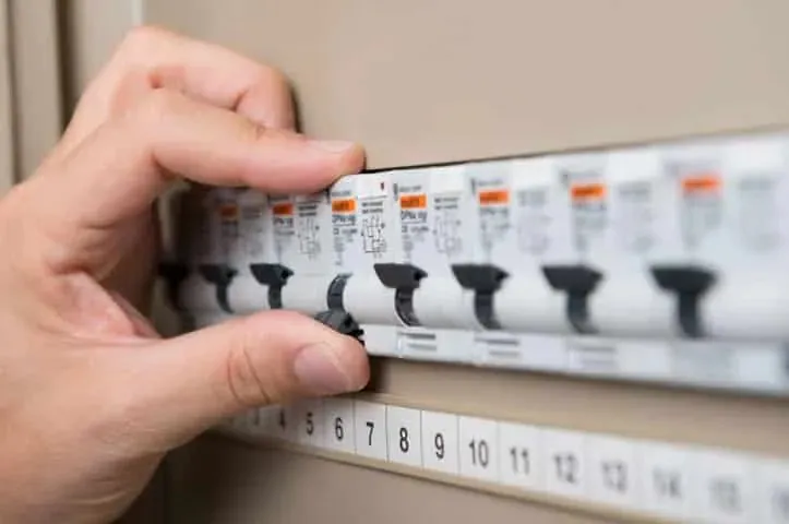 A hand on a switchboard breaker