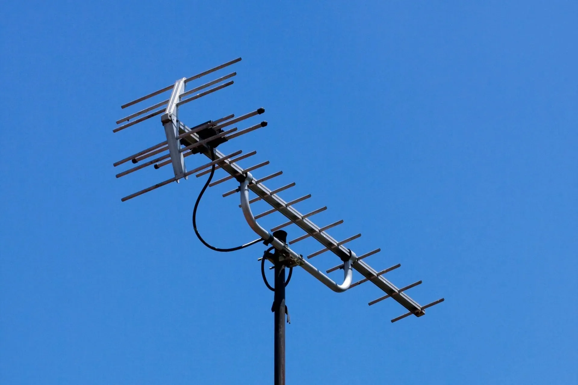 A TV antenna on a Newcastle rooftop against a blue sky